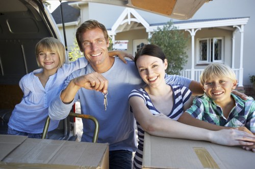 Professional movers carrying furniture from a Morden property
